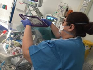 NICU nurse using vCreate on ipad over baby incubator