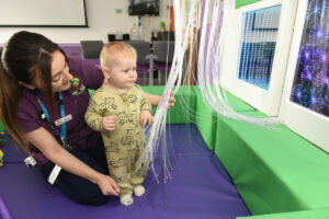 A child and member of staff using sensory equipment