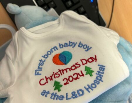 A vest saying 'first born baby boy at the L&D Hospital, Christmas Day 2024'