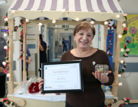 Nana laughing with her ROSE certificate and flower