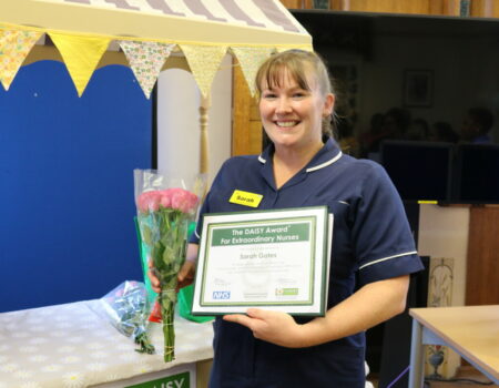 Sarah with her certificate and flowers