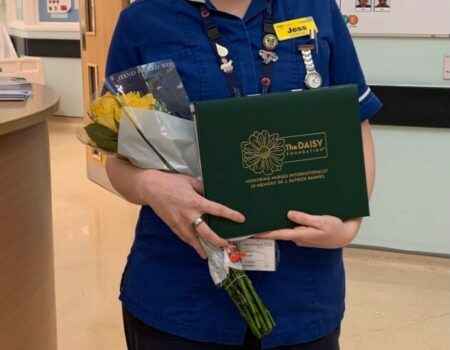 Jessica Plowman with her DAISY certificate and flowers