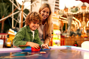 A child and mother playing air hockey